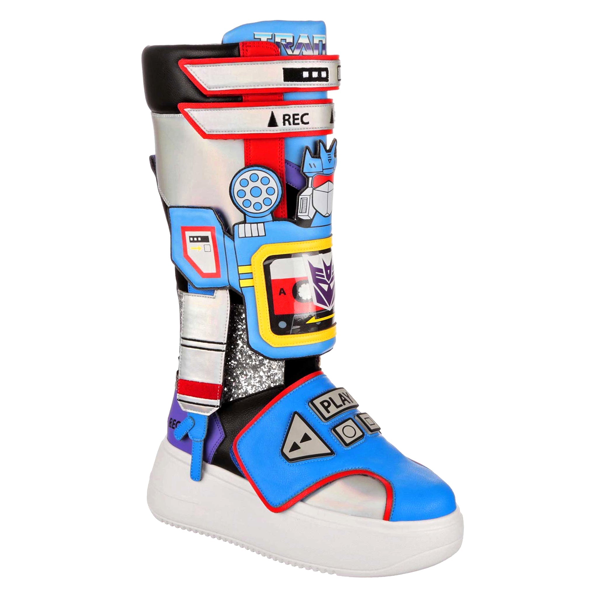 A Transformers themed Soundwave large multicoloured boot. These platform boots have a large white chunky platform with blue, silver and red details on the large knee high boot. They have retro cassette player design details over the boot with play, stop and record and a cassette deck with a purple decepticon logo on. Removable robot arms and Soundwaves face sits on the chunky boot to complete the look. 